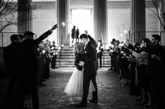 a bride and groom are kissing in front of sparklers at their wedding reception on the steps of an old building