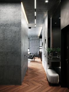 a long hallway with wooden floors and black walls is lit by recessed light fixtures