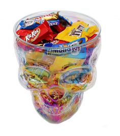 a bowl filled with candy and candies on top of a white background, in the shape of a human head