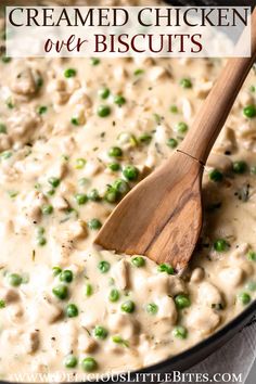 a wooden spoon in a pot filled with creamed chicken and pea biscuits