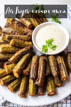 grilled asparagus with dipping sauce on a white plate