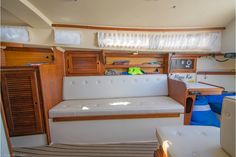 the inside of a sailboat with wood trimming and white leather couches on it