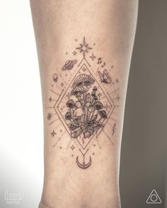 a tattoo on the leg of a woman with flowers and planets around her ankles,