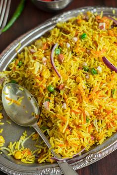 a silver plate topped with rice and veggies