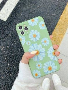 a person holding up a phone case with flowers on it