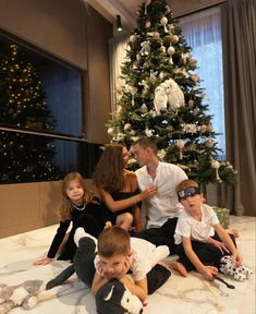 a family sitting in front of a christmas tree