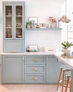 a kitchen with gray cabinets and white counter tops