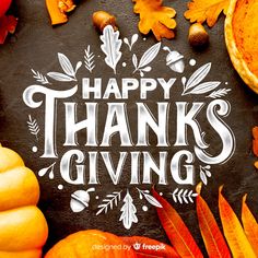 a chalkboard saying happy thanks giving surrounded by autumn leaves and pumpkins