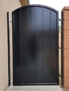 a black gate is open on the side of a building