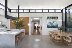 an open kitchen and dining room area with large painting on the wall behind the table