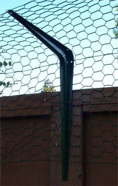 a baseball bat is in the batters box at home plate, with netting over it