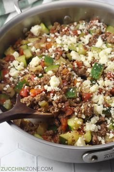 a pan filled with meat, vegetables and cheese