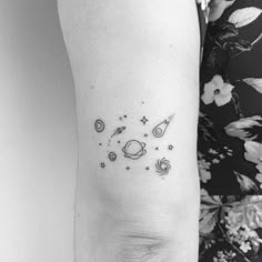 a woman's arm with an image of planets and stars tattooed on the side