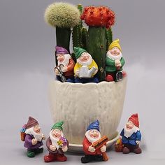 gnome figurines sitting in front of a cactus