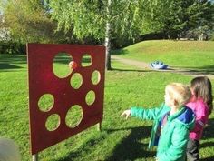 two young children are playing with an object in the grass