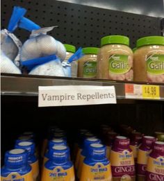 there are many bottles of food on the shelf in the store and one has a sign that says vampire repellents