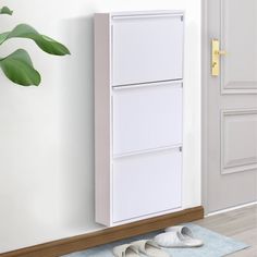 a pair of white shoes sitting on the floor in front of a wall mounted cabinet