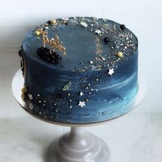 a blue cake with gold sprinkles on it