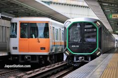 two trains are parked next to each other at the train station, one is orange and white