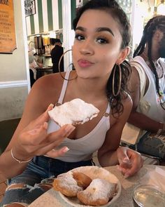 a woman sitting at a table with doughnuts in front of her