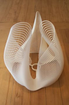 a white sculpture sitting on top of a wooden floor