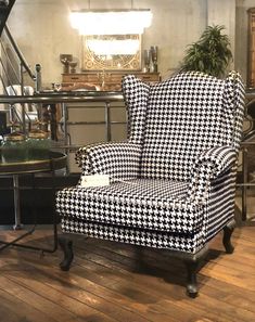 a black and white chair sitting on top of a hard wood floor