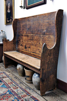 an old wooden bench with vases underneath it