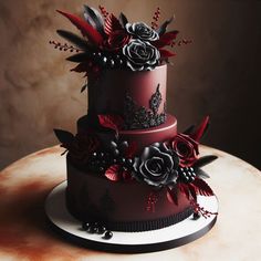 a three tiered cake decorated with red and black flowers