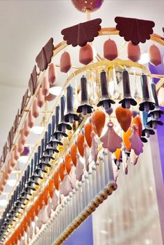 a chandelier with lots of different colored objects hanging from it's sides