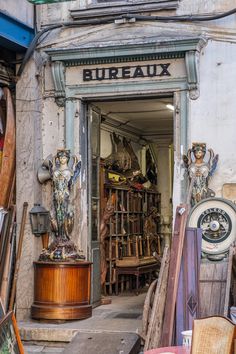 an old building with antiques in front of it and the door opened to show various items