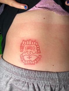 a woman's stomach with a red tattoo on the side of her belly and an image of a lion