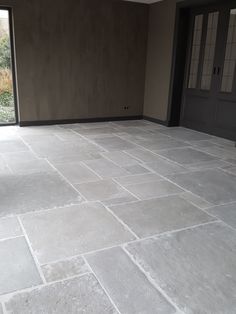 an empty living room with stone flooring and sliding glass doors