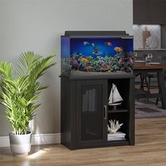 a fish tank sitting on top of a cabinet next to a potted plant