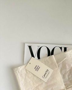 an envelope with a tag sitting on top of it next to a sign that says voce