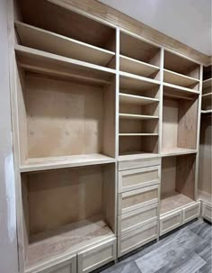 an empty walk in closet with drawers and shelves