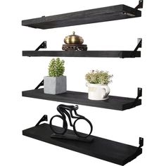 three black shelves with pots and plants on them, one shelf has a bike handle