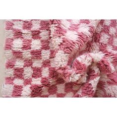 a pink and white blanket on the floor