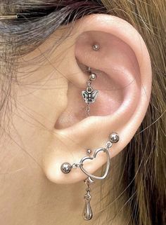 a close up of a person's ear with some piercings on it