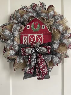 a red barn wreath hanging on the front door