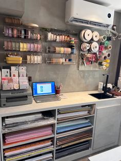 a computer on top of a desk in a room with many different types of fabrics