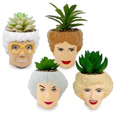 four ceramic pots with plants in them and faces on the top one has an older woman's face