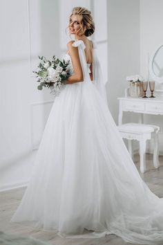 a woman in a white wedding dress holding a bouquet