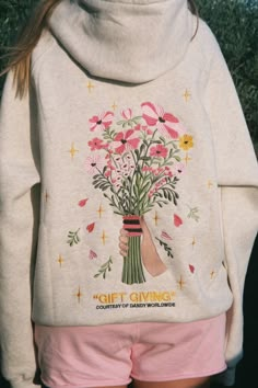 Photo shows a closeup of the back of a teenage girl wearing pink sweatshorts and a heather gray Dandy Worldwide hoodie that has an embroidered graphic of a hand holding a bouquet of pink flowers with "gift giving" embroidered underneath in yellow. There are also yellow embroidered sparkles and pink hearts on the back. Best Friend Hoodie Ideas, Cute Hoodie Ideas, Dandy Worldwide, Camry 2015, Camouflage Hoodie, Sunscreen Moisturizer, Birthday Outfits, Cute Sweatshirts, Gentle Cleanser