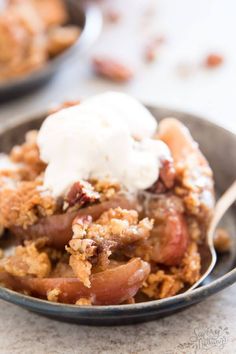 a close up of a bowl of food with ice cream on top and fruit in the background