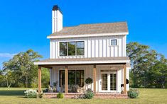 a white house sitting on top of a lush green field