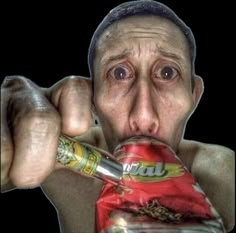 a man eating a bag of food with his mouth wide open and holding a drink in front of his face