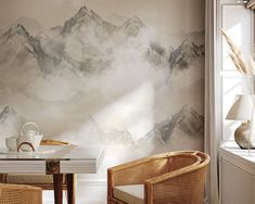 a dining room table with two chairs and a wallpapered mountain scene behind it