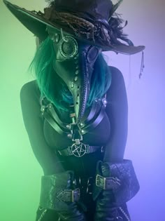 a woman with green hair wearing a black hat and leather gloves on her head,