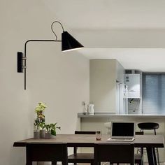 a laptop computer sitting on top of a wooden table in front of a white kitchen