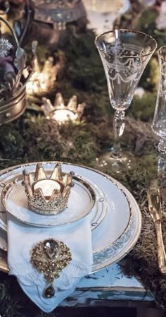 a table set with plates, silverware and candles